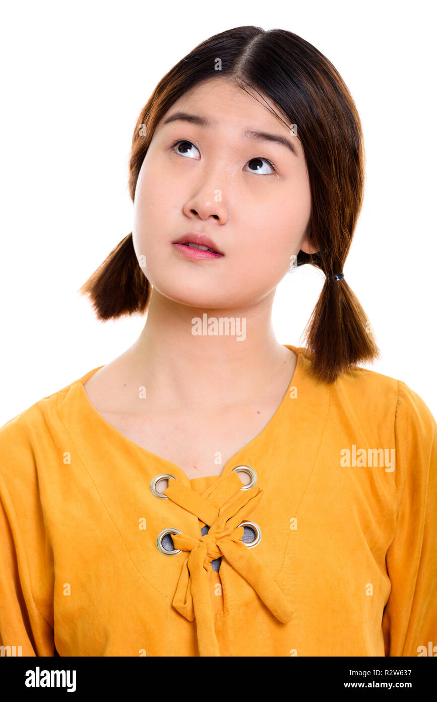 Face of young beautiful Asian woman thinking Stock Photo