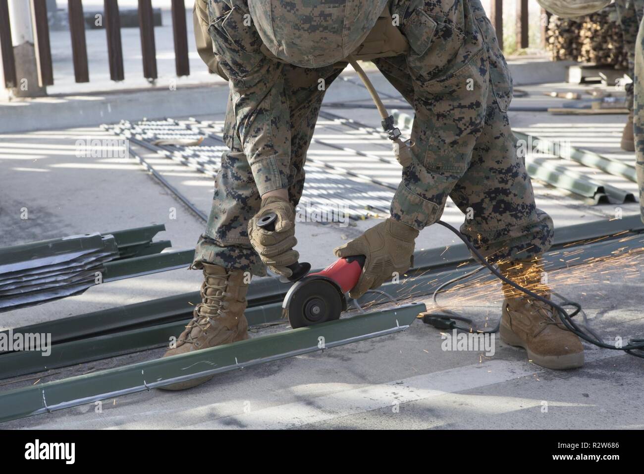 U.S. Marine Lance Cpl. Cristian Rivera, a combat engineer with 7th Engineer Support Battalion, Special Purpose Marine Air-Ground Task Force 7, grinds notches onto engineer steaks in preparation to reinforce the California-Mexico border near the Otay Mesa Port of Entry, Nov. 13, 2018. U.S. Northern Command is providing military support to the Department of Homeland Security and U.S. Customs and Border Protection to secure the Southern border of the United States. Stock Photo