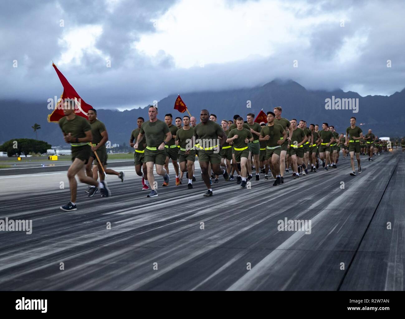 U.S. Marines and Sailors with Marine Corps Air Station (MCAS) Kaneohe Bay and Headquarters Battalion, Marine Corps Base Hawaii, run the length of the MCAS Kaneohe Bay runway to celebrate the 243rd Marine Corps Birthday, Nov. 7, 2018. The birthday run was 3.4 miles and provided a rare opportunity to traverse the runway on foot. Stock Photo