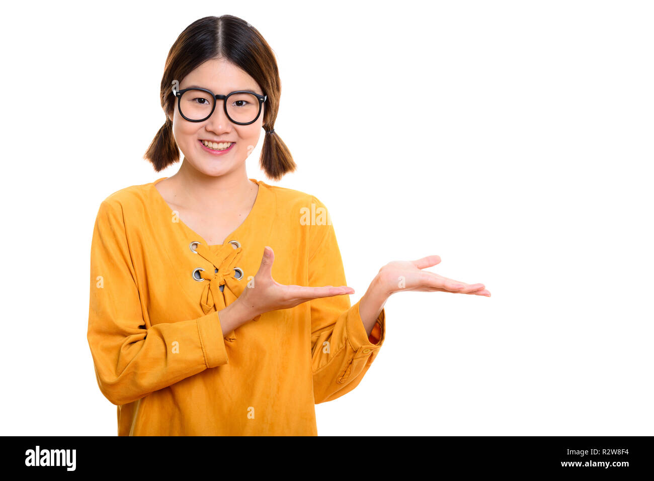 Studio shot of young happy Asian woman smiling while showing som Stock ...