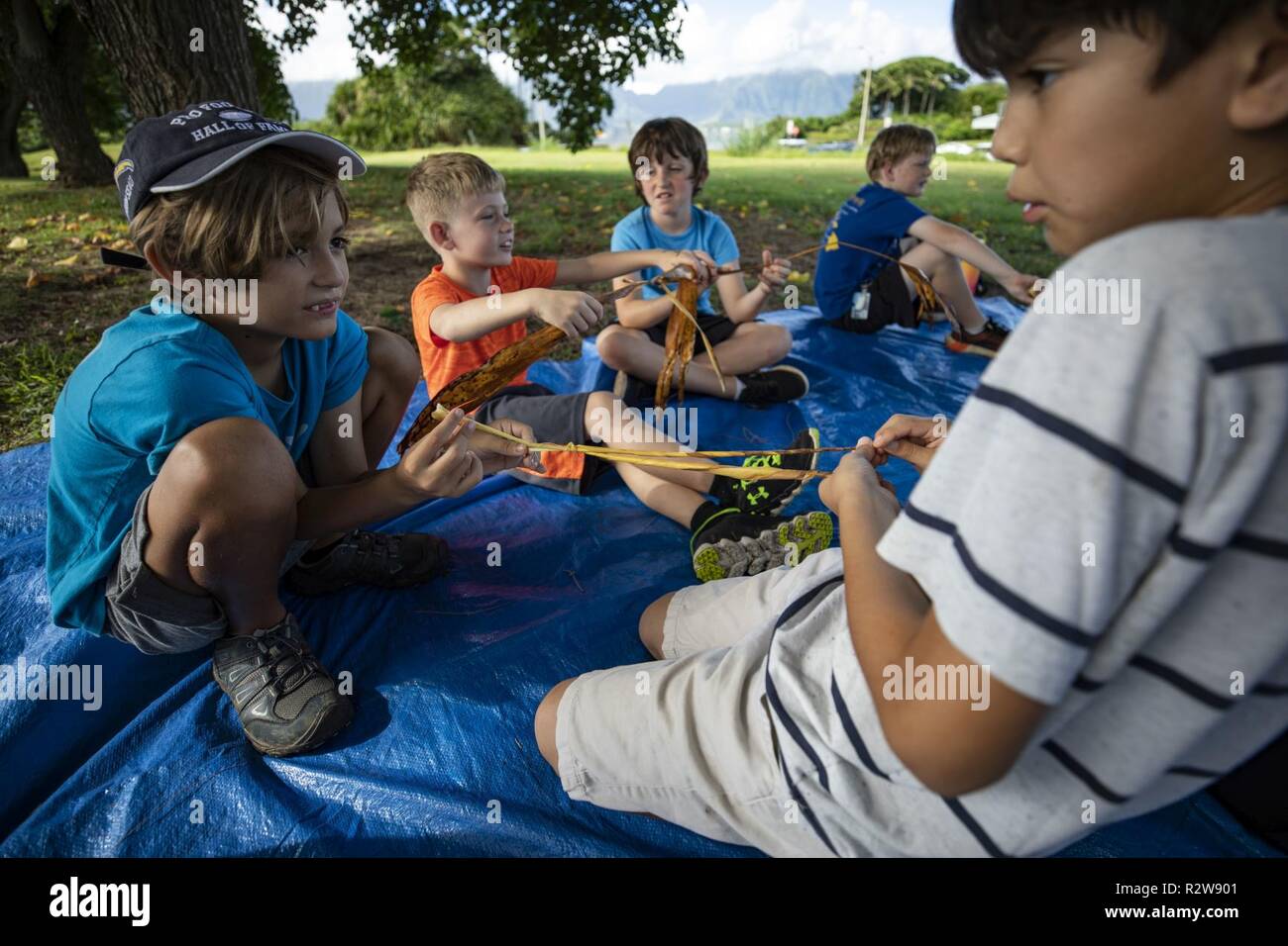Students with Mokapu Elementary School learn to make traditional tea leaf bracelets at Nu’ Upia Ponds during a field trip, Marine Corps Base Hawaii, Nov. 14, 2018. The base’s Environmental Department partnered with the school to host a cultural learning field trip to teach students the significance of the ponds and the Hawaiian culture. Stock Photo