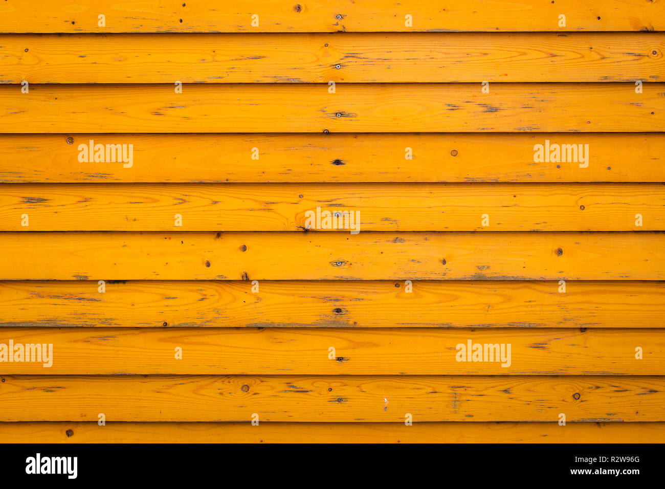 Horizontal old wood fence background. Old wooden planks with bright yellow paint Stock Photo