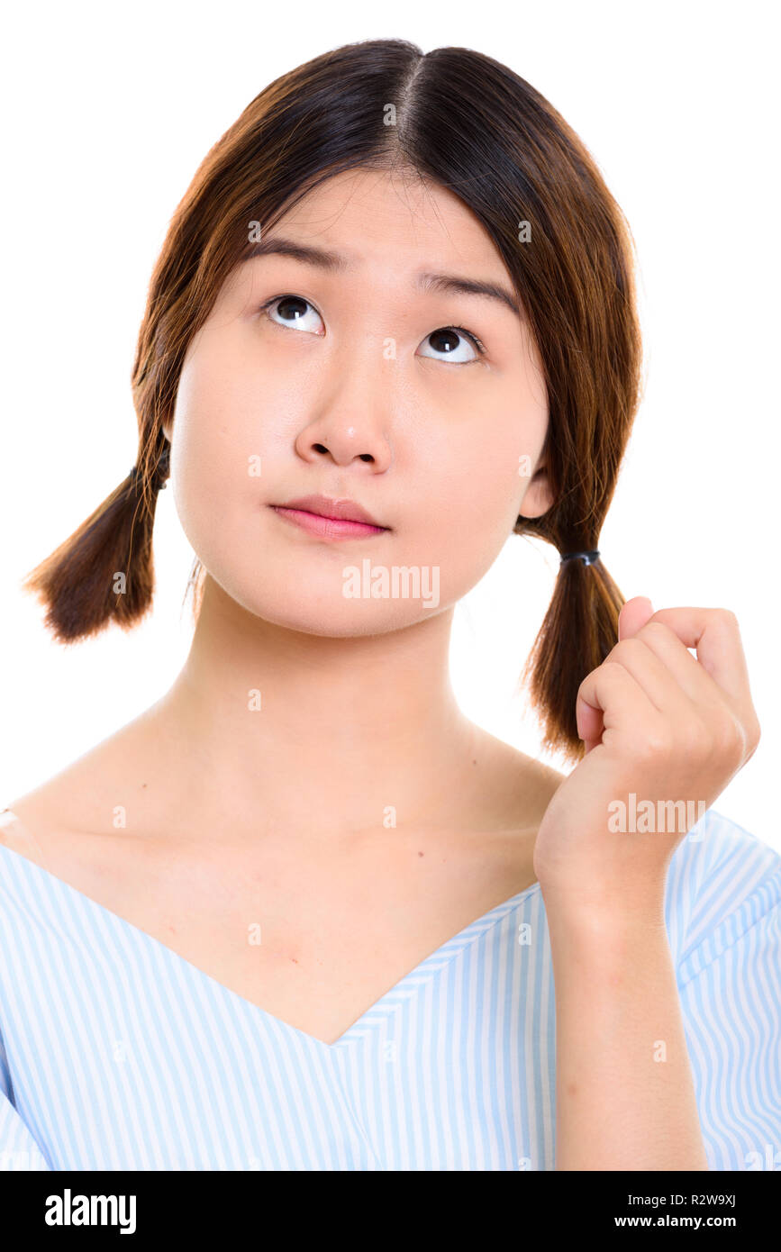 Face of young beautiful Asian woman thinking while looking up Stock ...
