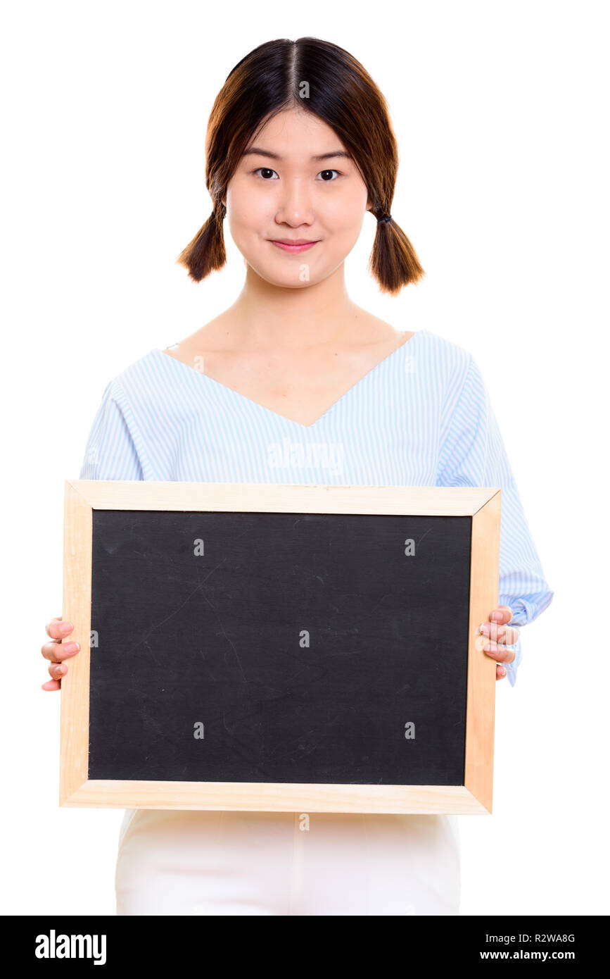 Studio shot of young beautiful Asian woman holding blank blackbo Stock Photo