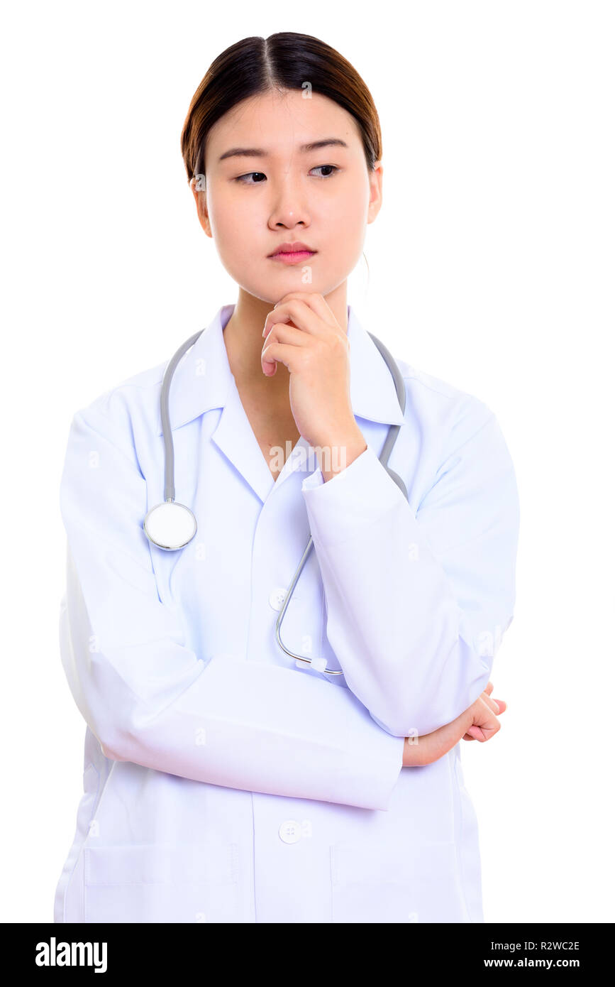 Studio shot of young beautiful Asian woman doctor thinking Stock Photo ...
