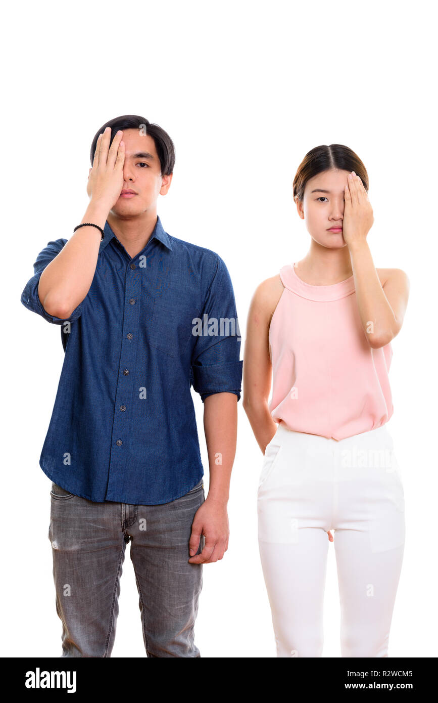 Studio shot of young Asian couple covering face together Stock Photo