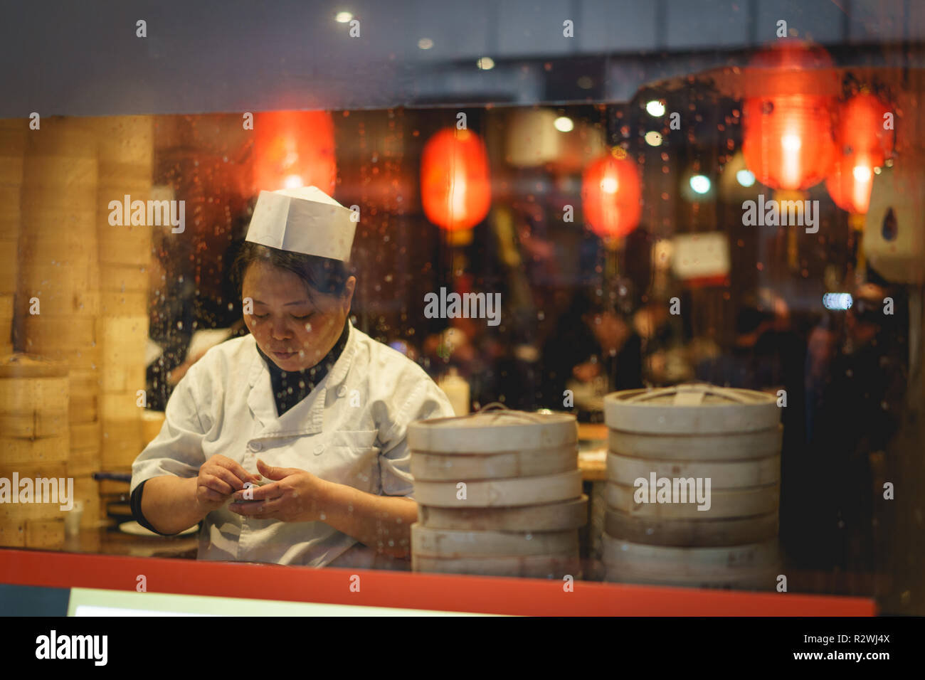 London, UK - February, 2019. A female cook preparing dumplings in a restaurant in China Town in Soho. Stock Photo