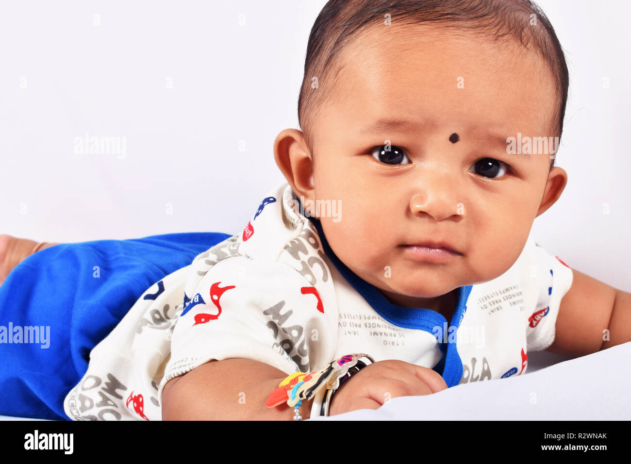 Cute baby sleeping on bed on stomach looking at camera, Pune, Maharashtra Stock Photo Alamy