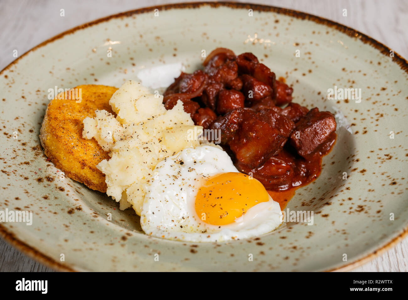 Romanian traditional food, polenta with fried egg and spicy meat and