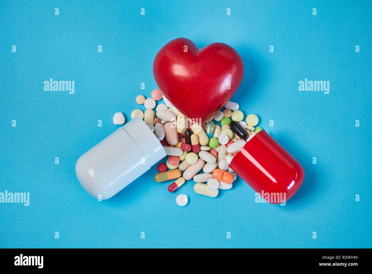 Red heart on broken capsule with medication as a heartbroken concept Stock Photo