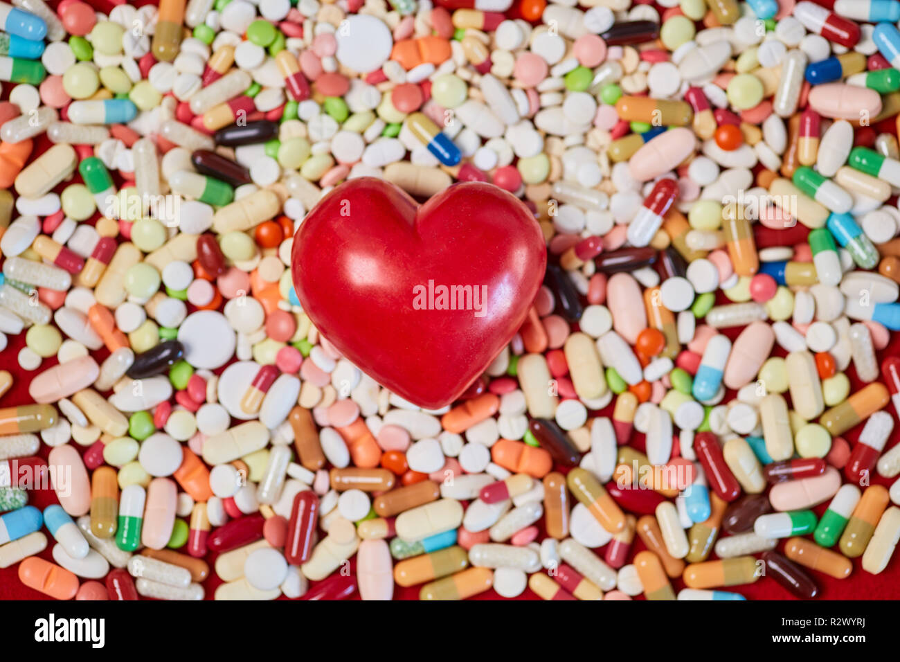 Red heart lies on many colorful medicines Stock Photo