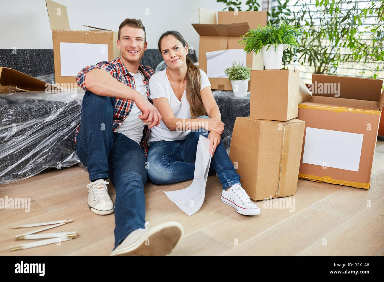 Young couple between moving boxes when moving to new apartment or house Stock Photo