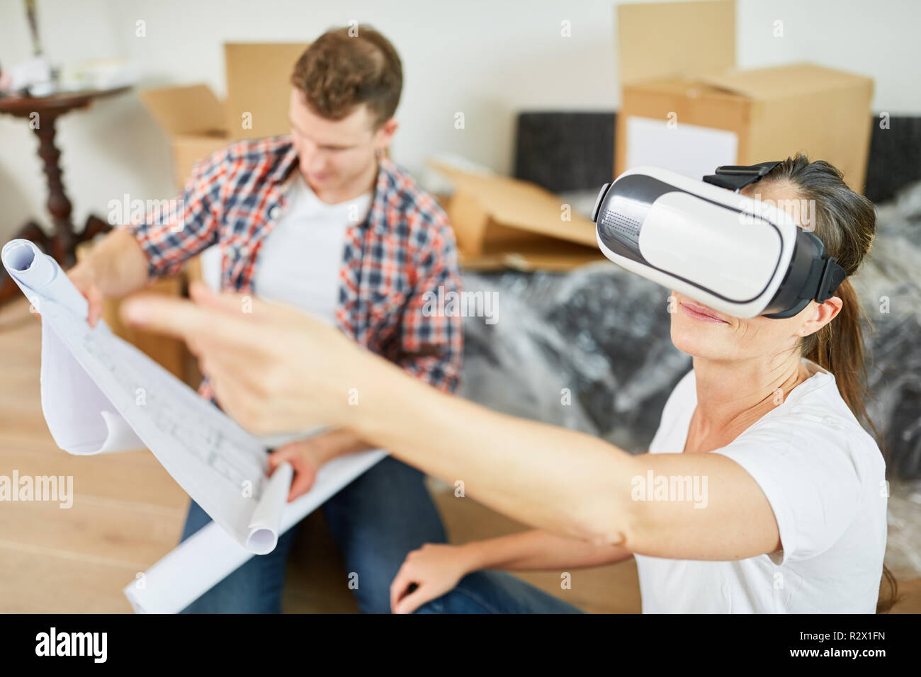 Young woman makes room planning with the VR glasses after moving to the new house Stock Photo