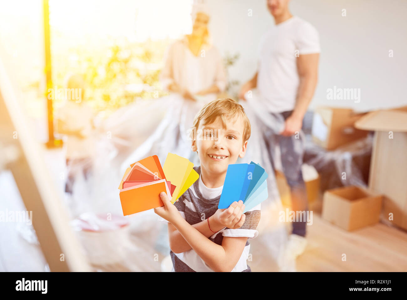 Child helps family choose wall paint when renovating their home Stock ...