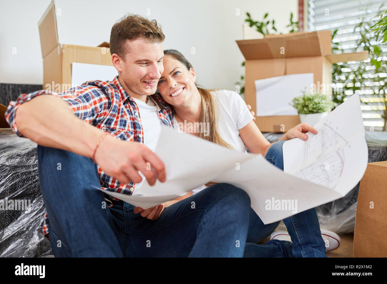 Couple in love planning home construction with construction drawing before move Stock Photo