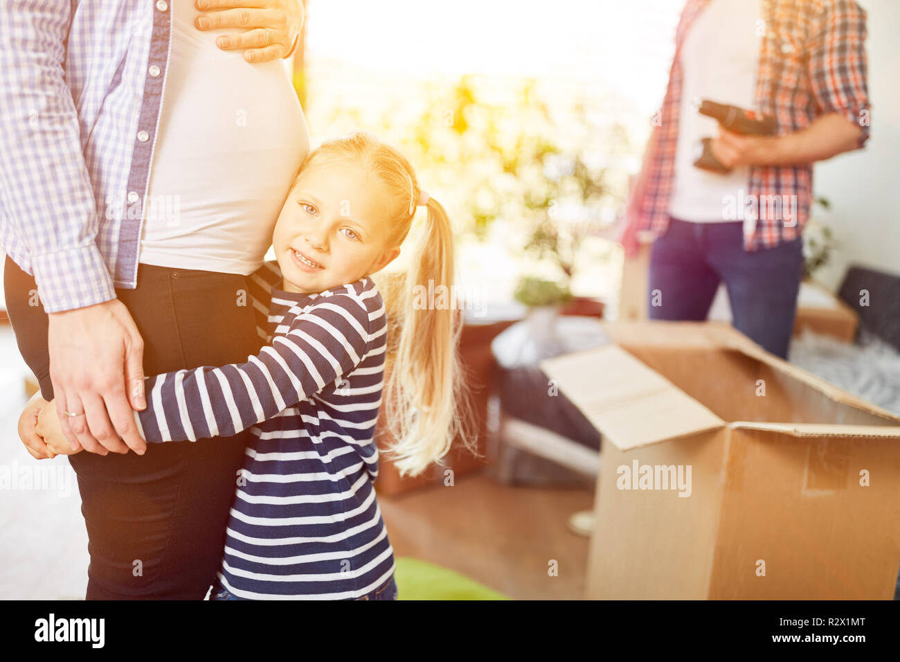 Child stops baby belly of pregnant mother moving to home Stock Photo