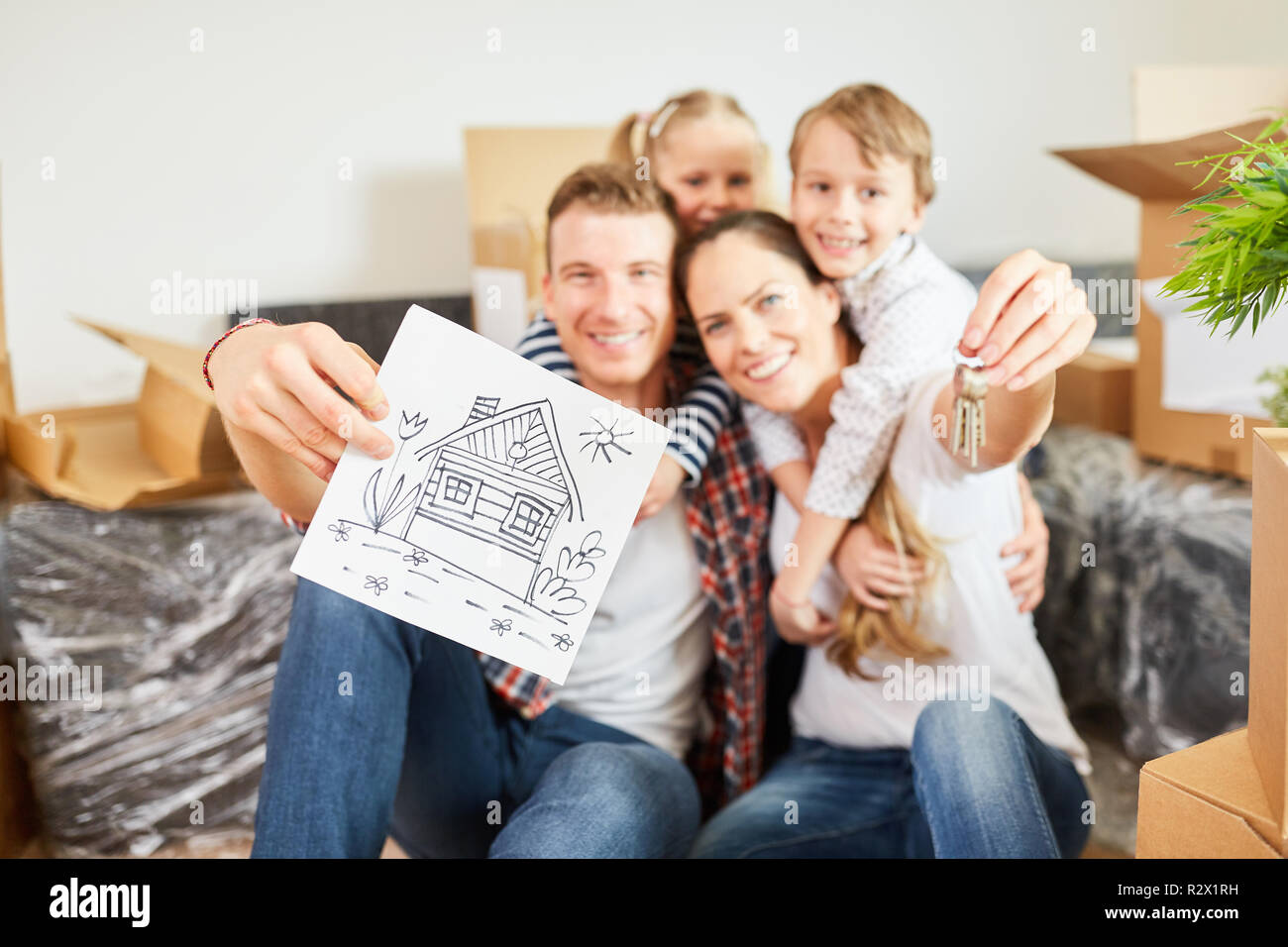 Happy family with home drawing and key to move in Stock Photo
