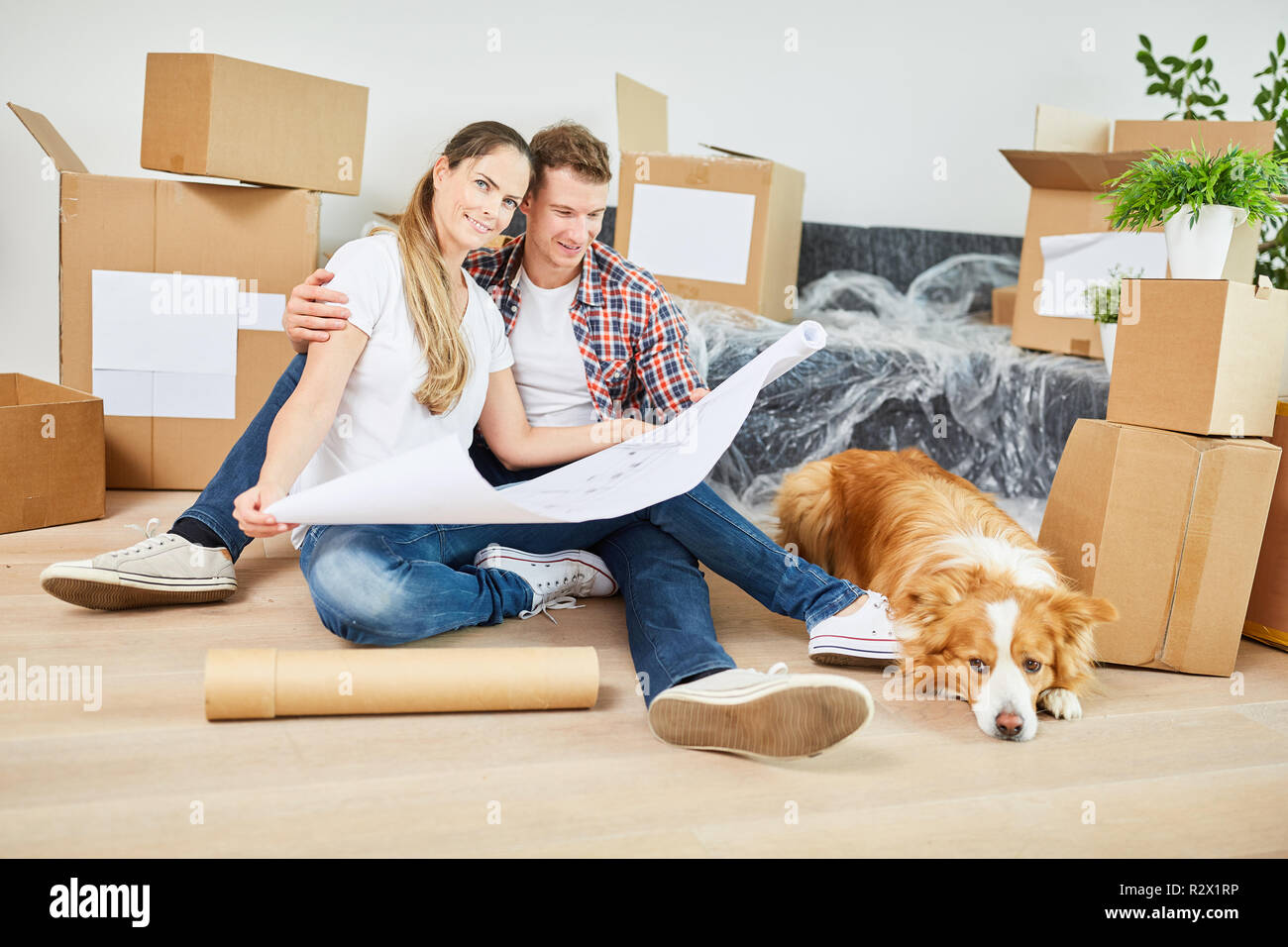 Young couple after moving with Baupan between many moving boxes Stock Photo
