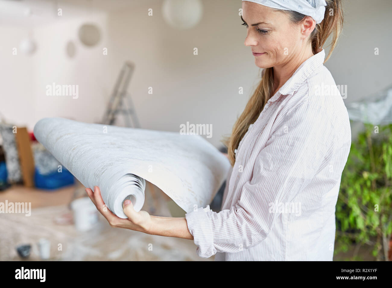 Woman as a home improvement during renovation deliberates when choosing a wallpaper Stock Photo
