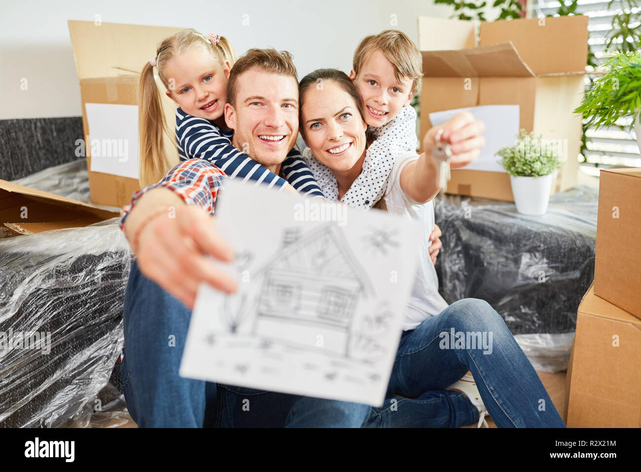 Happy family with picture of house as a sign for real estate and property Stock Photo