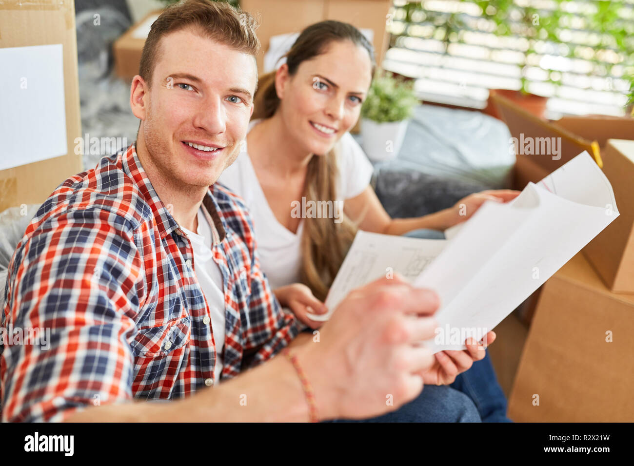 Young couple planning the new house together and studying architectural drawings Stock Photo