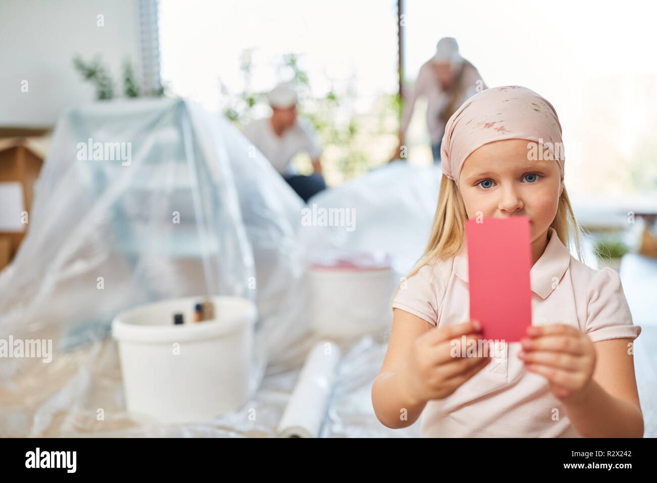 Girl renovating decides on pink wall paint in the room Stock Photo