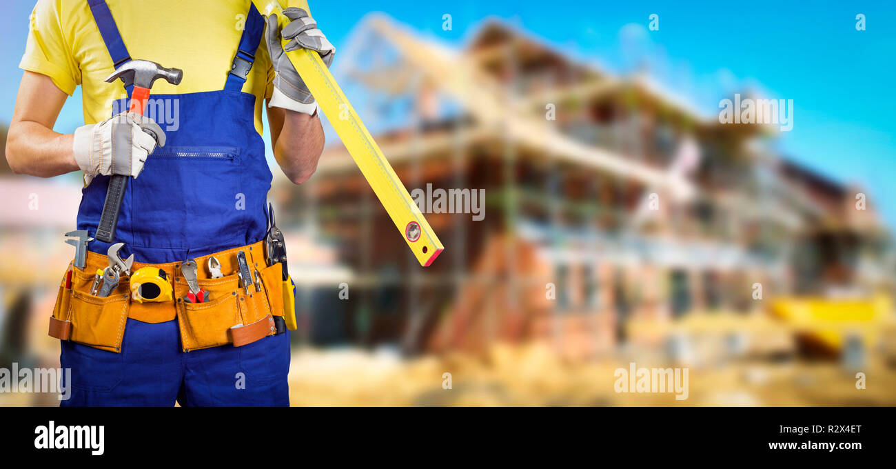 worker with tool belt in house construction site Stock Photo