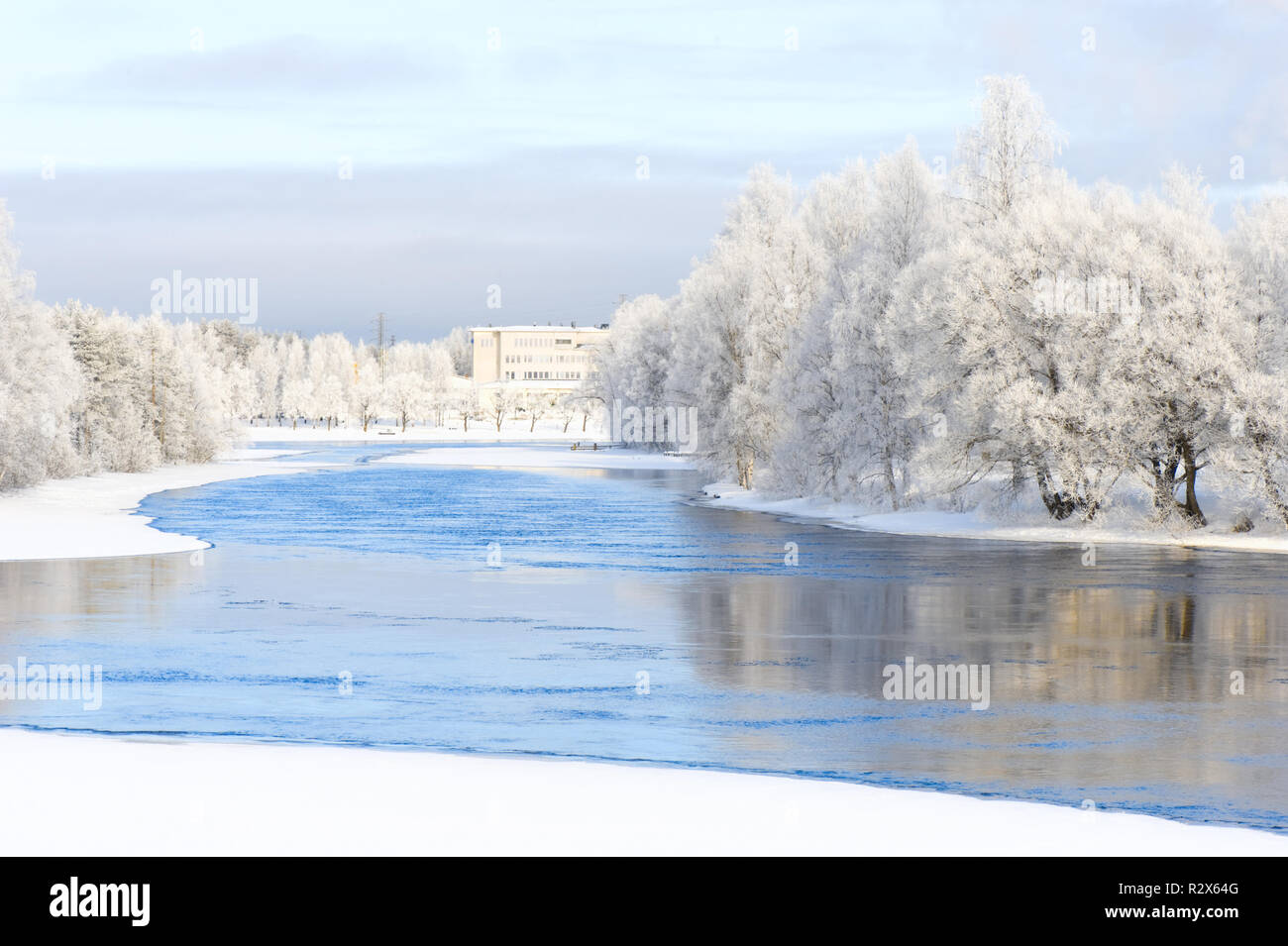 Winter river scenery with frost covered trees on riverbank. Stock Photo