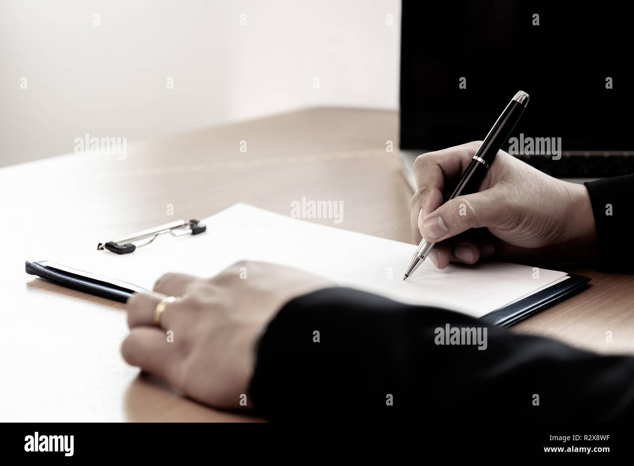 Businessman at office desk signing a contract form in office. Stock Photo