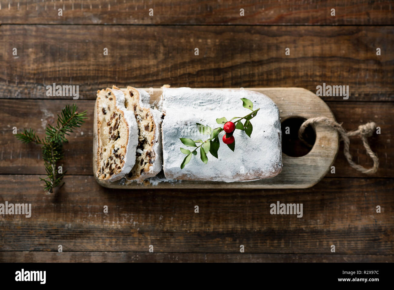 high angle view of a stollen cake for christmas time sprinkled with icing sugar, placed on a wooden rustic table Stock Photo