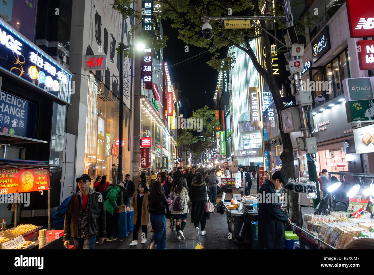 Streets of Myeongdong in Seoul, South Korea busy with shoppers and tourists at night.  Lights from shops and shop signs light up the street Stock Photo