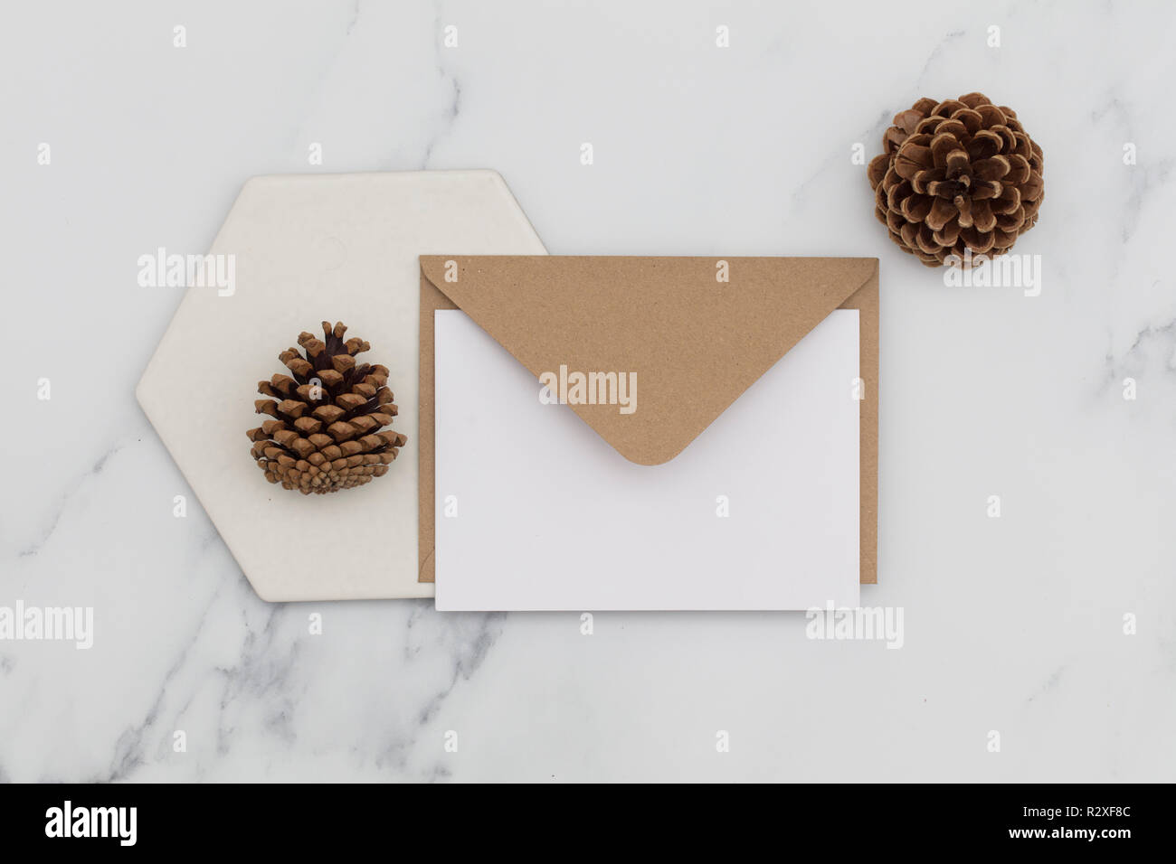 Blank white card with kraft brown paper envelope on marble background ...