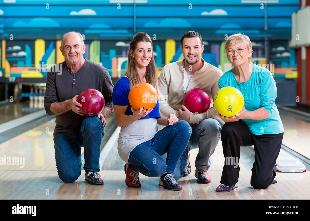 Family with multi colored bowling ball posing Stock Photo