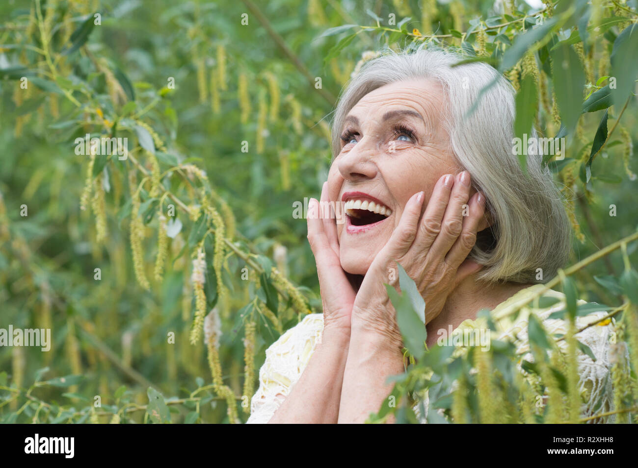 Portrait of a cute beautiful senior woman in green park Stock Photo - Alamy