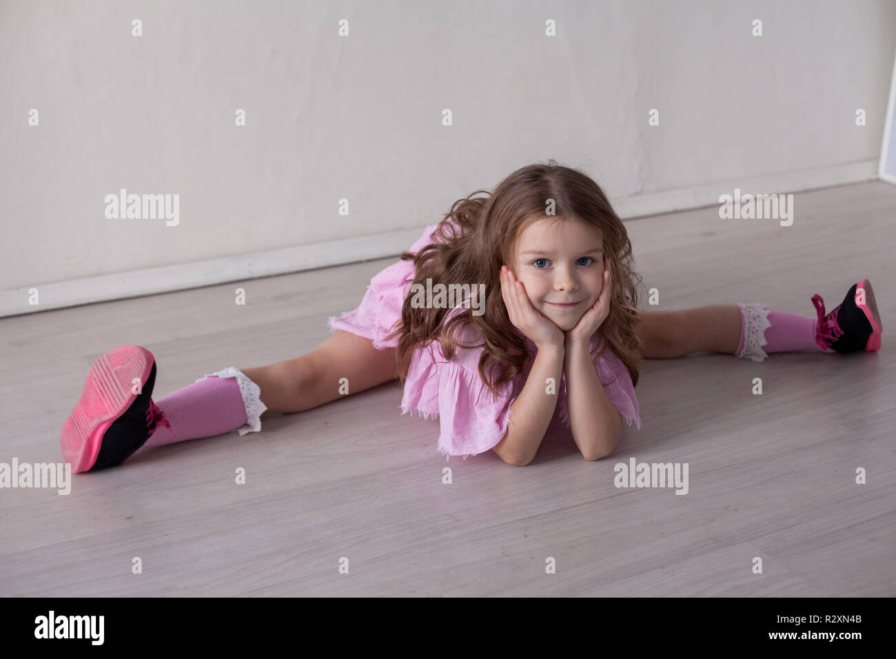 small beautiful girl sitting on the floor playing Stock Photo - Alamy