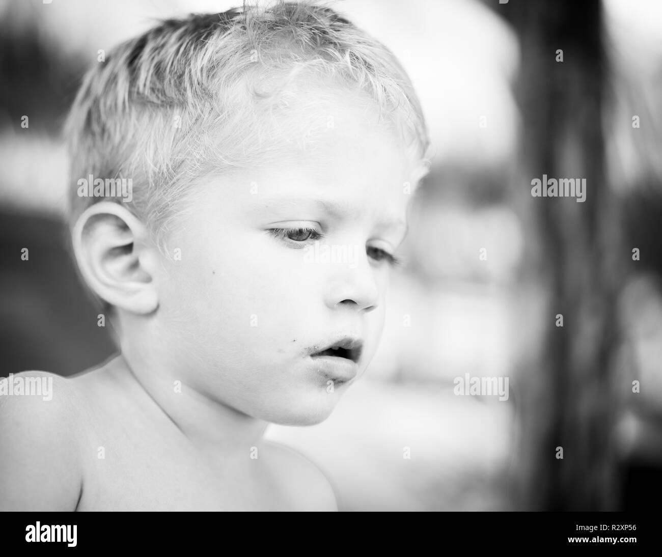Portrait of caucasian white infant boy with chocolate on his face,black and white photo. Stock Photo
