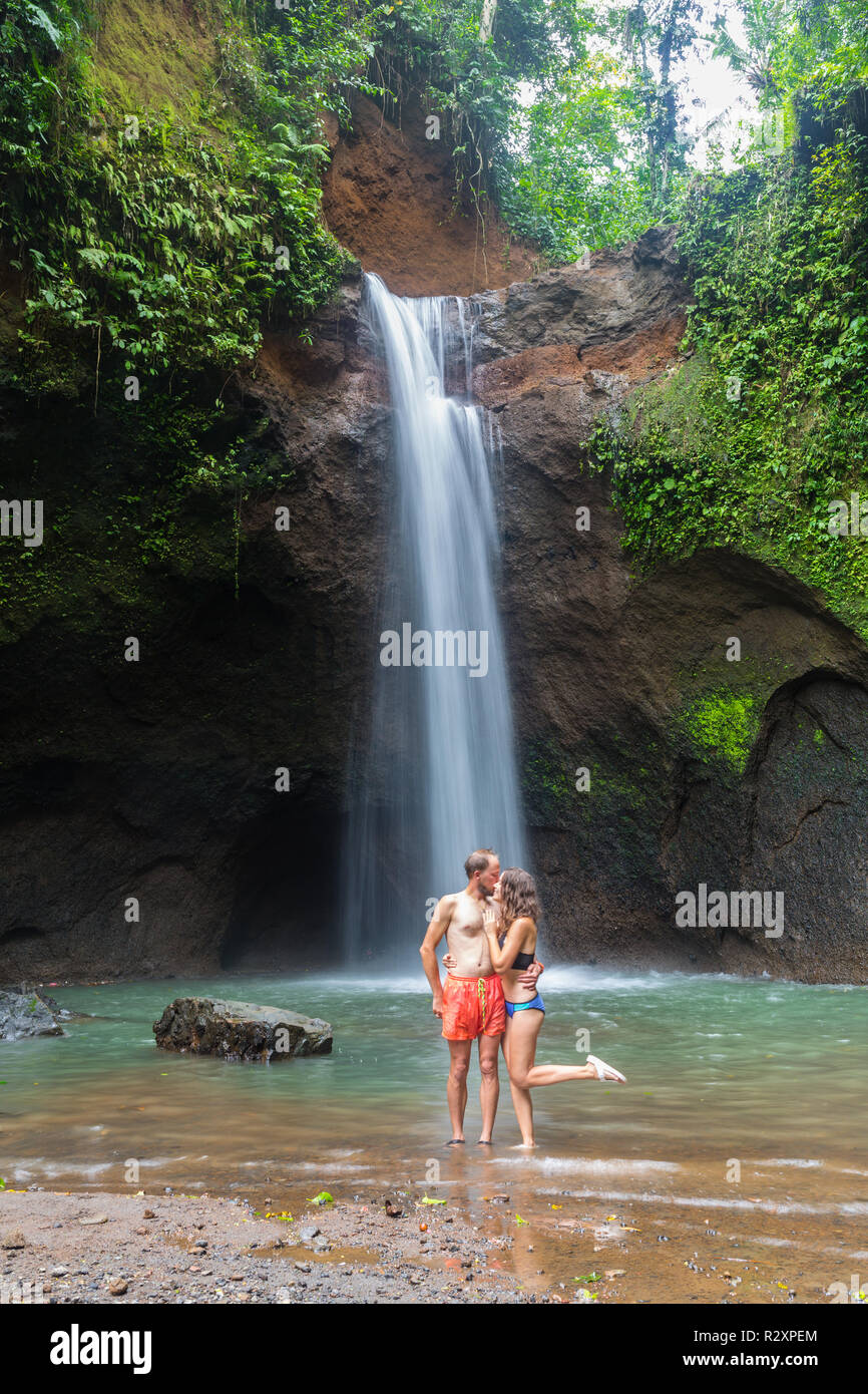 couple looking at the gorgeous waterfall in Bali Stock Photo