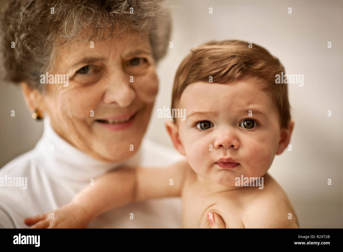 Portrait of a woman holding her granddaughter. Stock Photo
