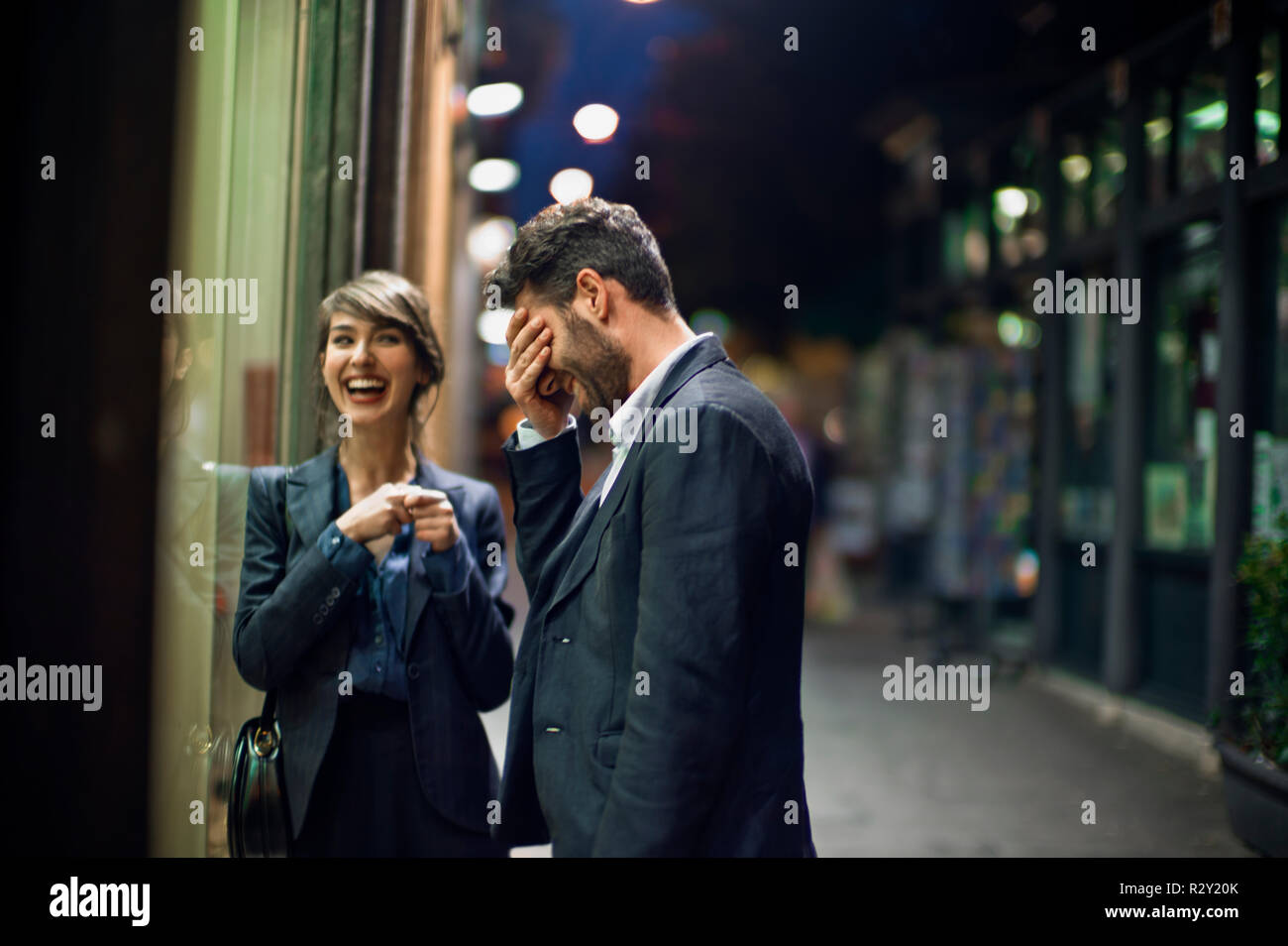 Young man is embarrassed by something he just said while on an after-work date with a female colleague. Stock Photo