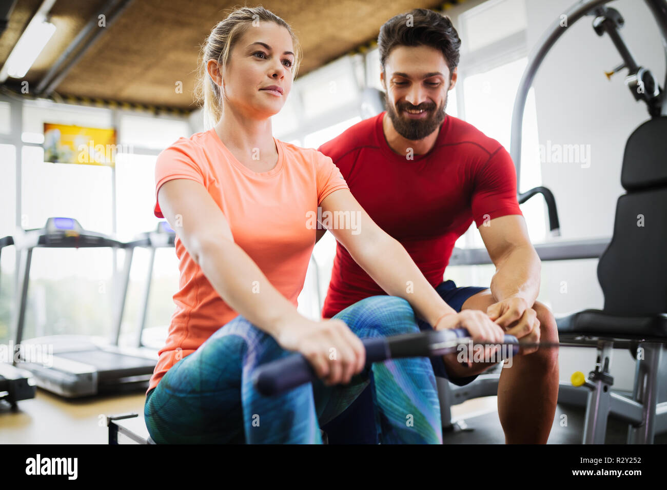 Young beautiful woman doing exercises with personal trainer Stock Photo