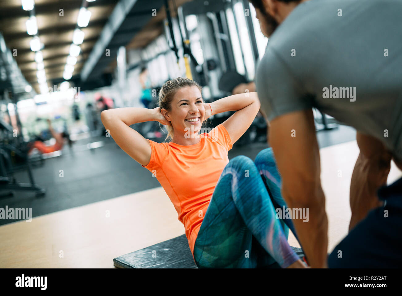 Personal Trainer Helping Woman at Gym Stock Image - Image of power, people:  39983181