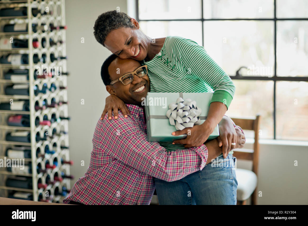 Smiling Middle Aged Woman Hugging Her Husband After Receiving A Birthday Present Stock Photo Alamy