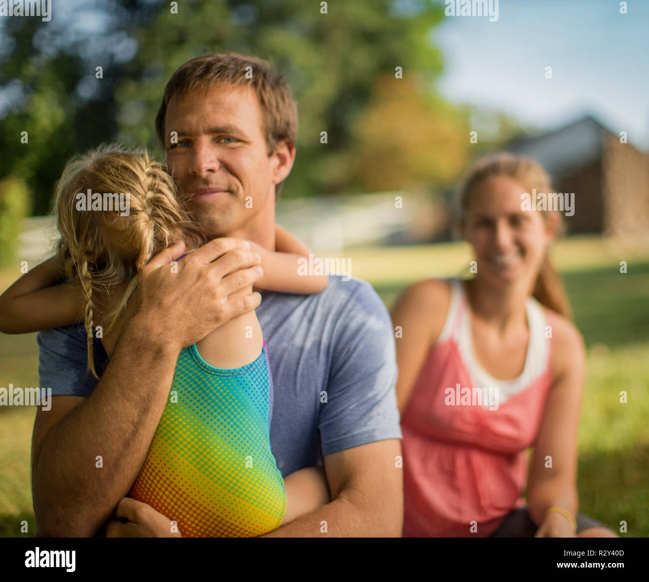 Portrait of a middle-aged father gently hugging his young daughter. Stock Photo