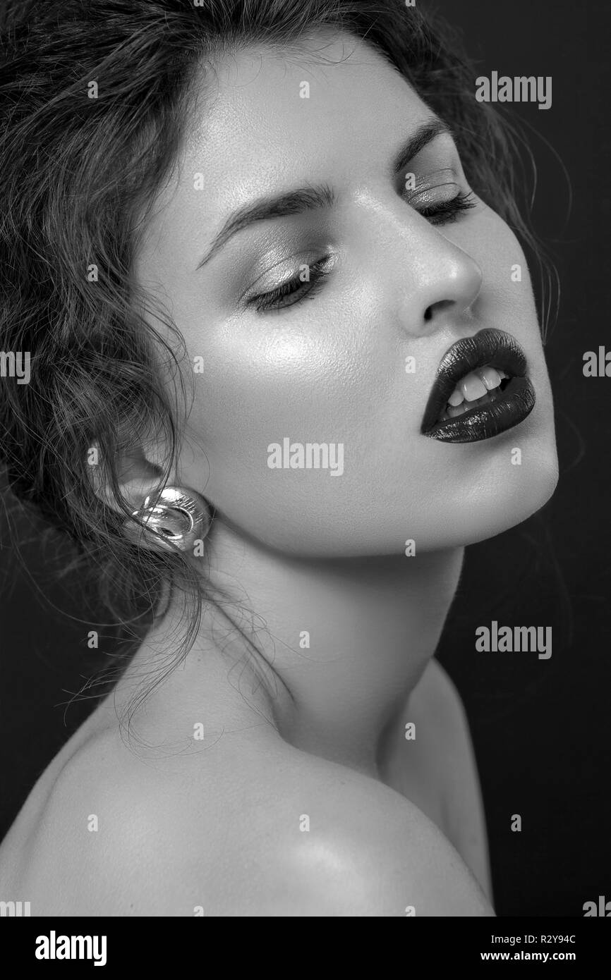 beauty portrait of young female posing with bare shoulders on dark ...