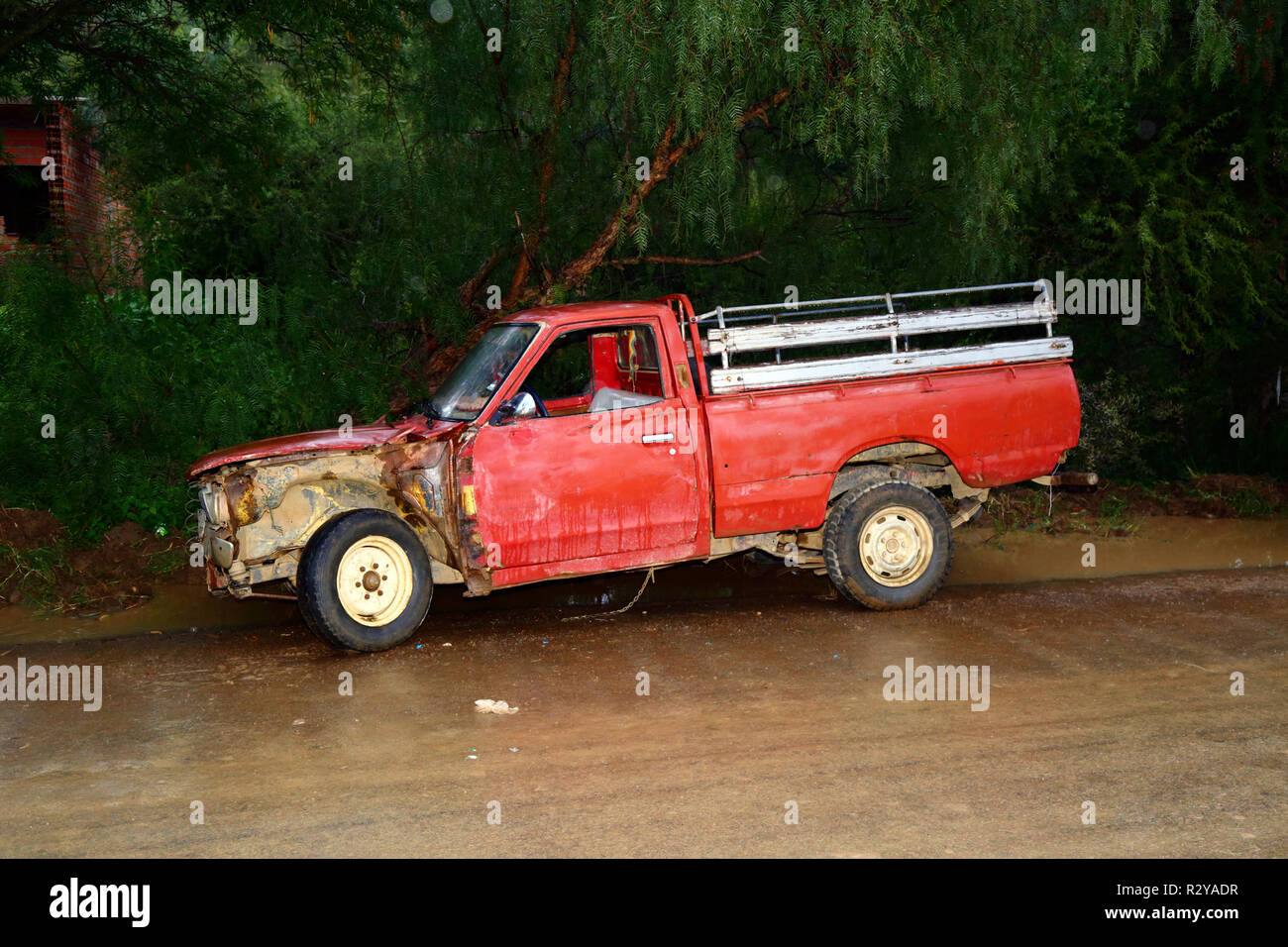 Old red pickup truck in bad condition parked next to road near Tarija, Bolivia Stock Photo