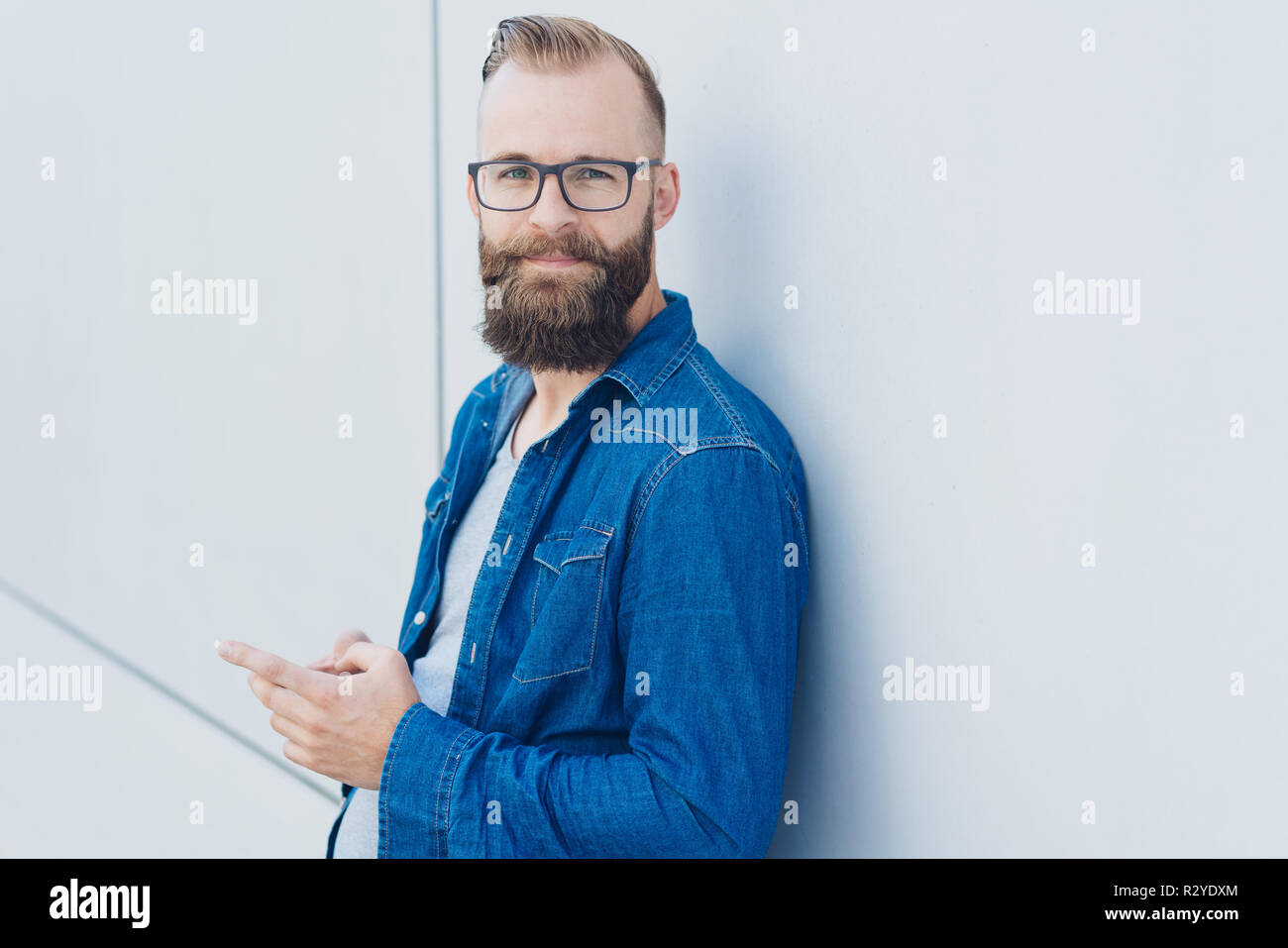 Hipster Young Man With Short Haircut And Beard Wearing Glasses