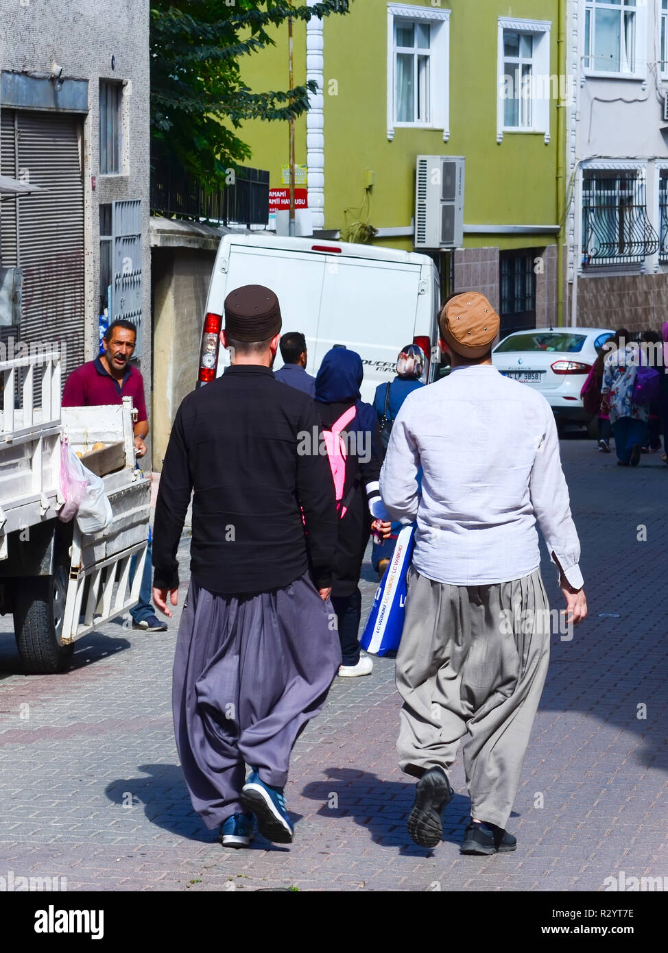 Istanbul, TURKEY, September 20, 2018: Two Muslim men in traditional clothes go shopping on the street of the old city Stock Photo