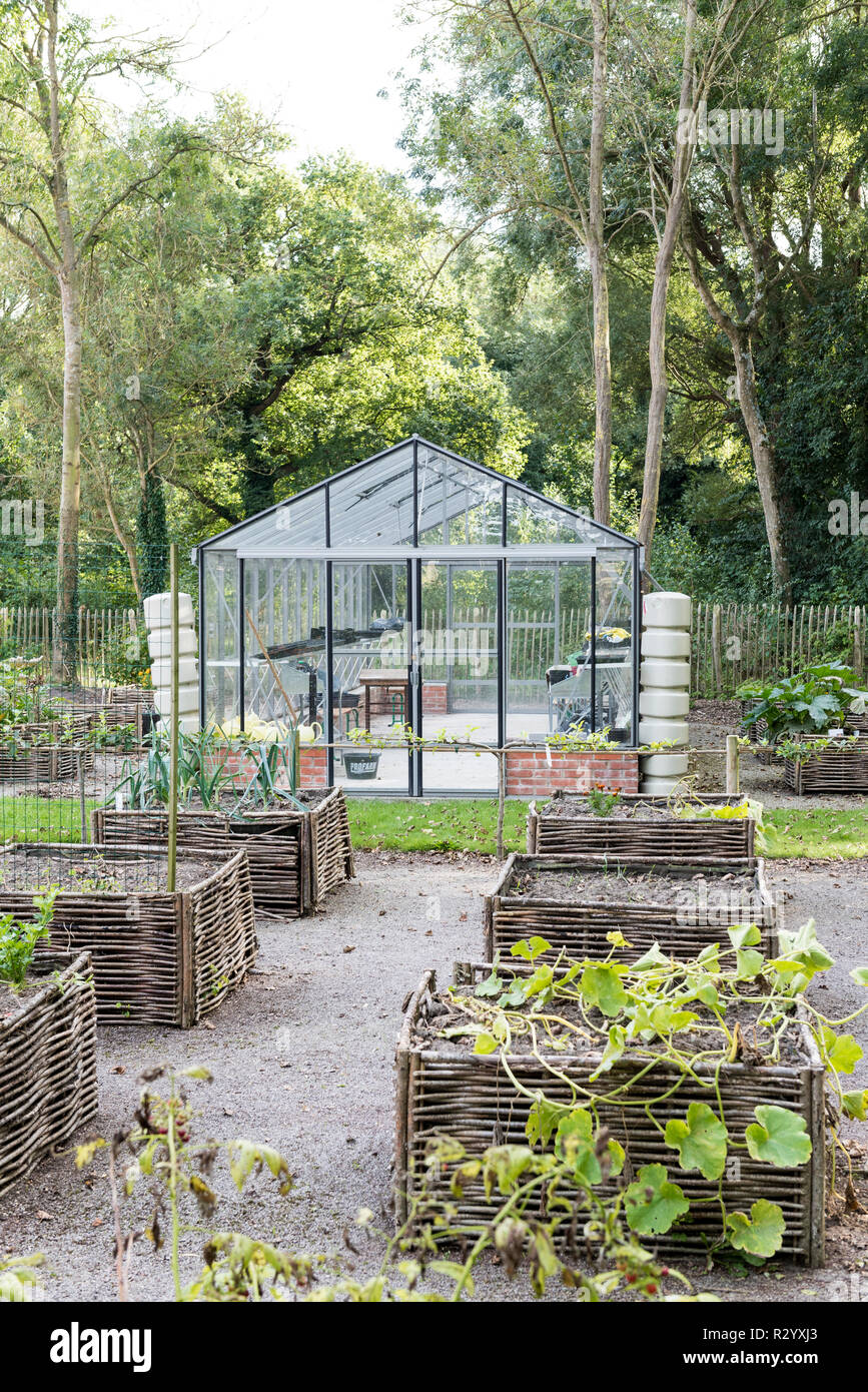 Greenhouse and square foot gardens with hazel wood weave Stock Photo