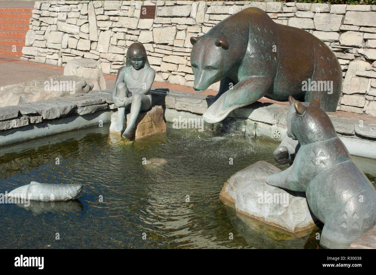 Chumash child with bears and fish, a fountain at San Luis Obispo Mission, California, sculpted by Paula Zima. Digital photograph Stock Photo