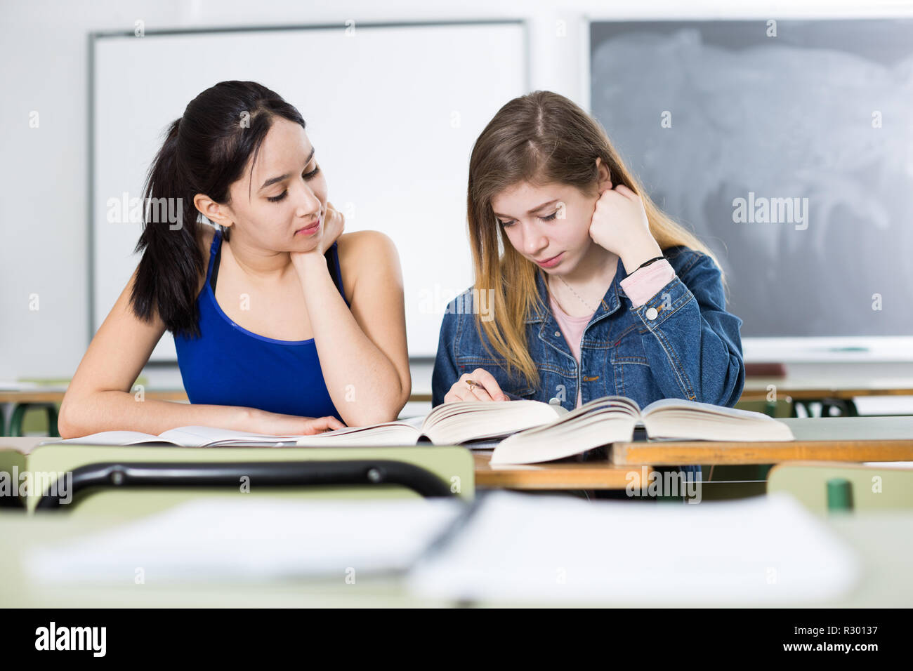 Smiling schoolgirls are learning at the desk in the class Stock Photo ...